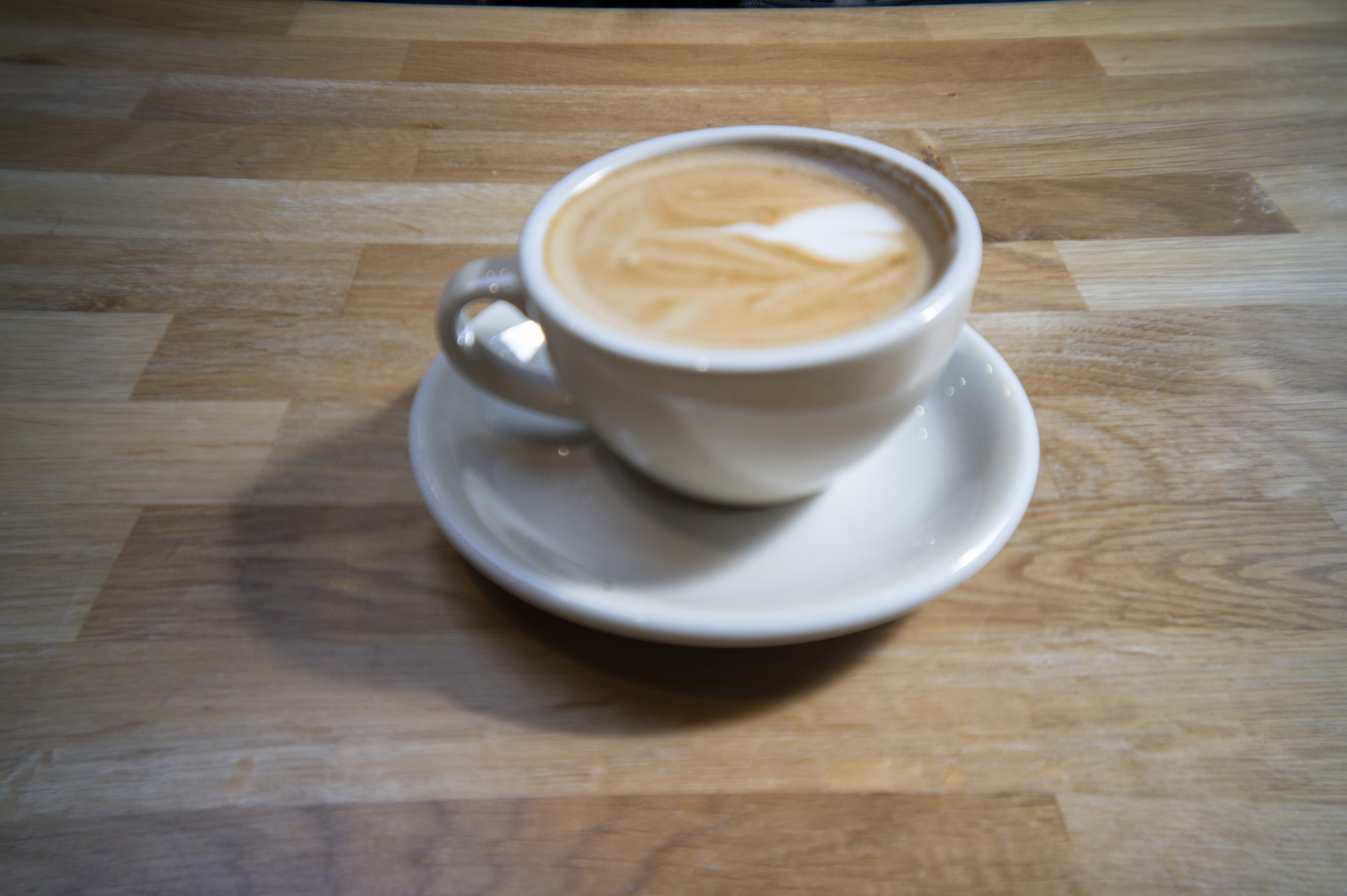 A cup of coffee in a cafe on a wooden surface