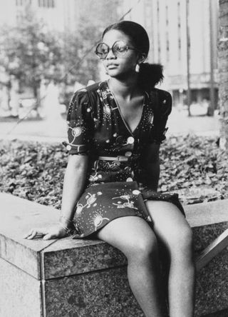 A young woman, wearing a minidress and sunglasses, deep in thought as she sits on the lip of a concrete planter, United States, circa 1965. (Photo by Bill Price/FPG/Archive