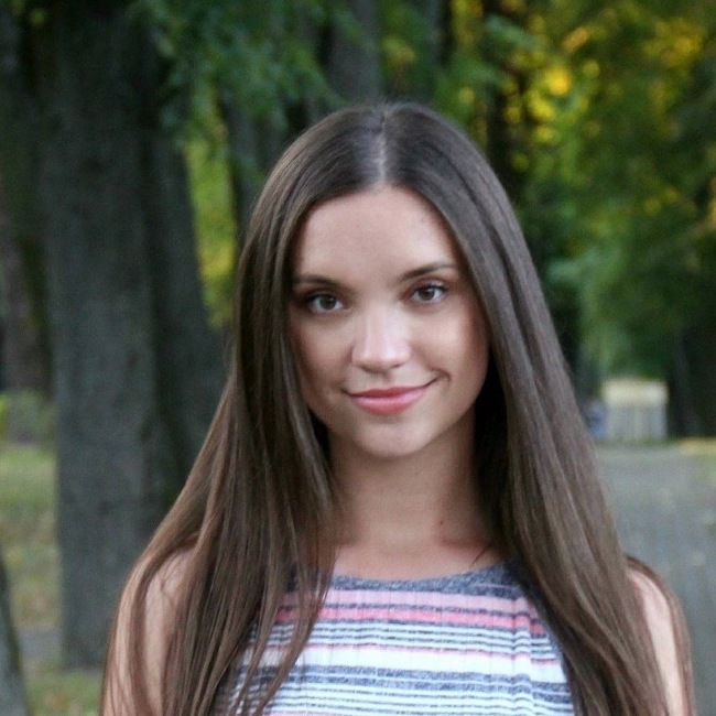 young woman with long brown hair smiling to camera