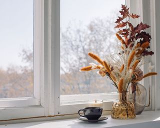windowsill with fall decor and candle