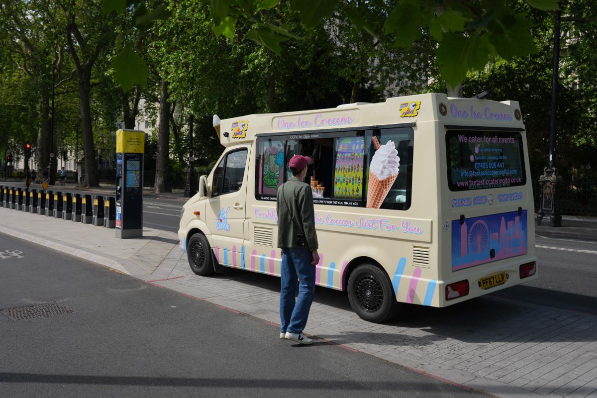 Ice cream van parked near Westminster with a customer at the window.