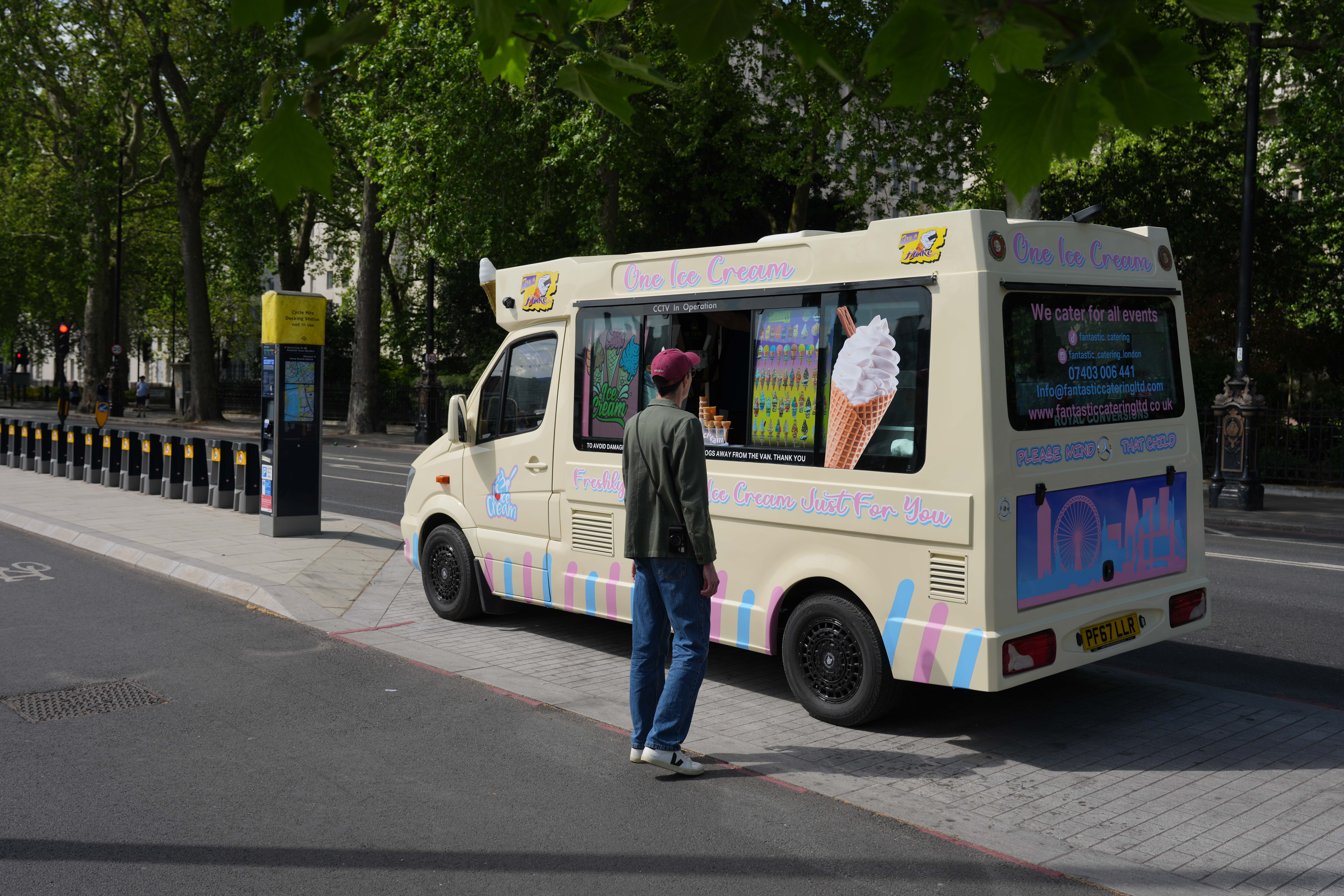 Ice cream van parked near Westminster with a customer at the window.