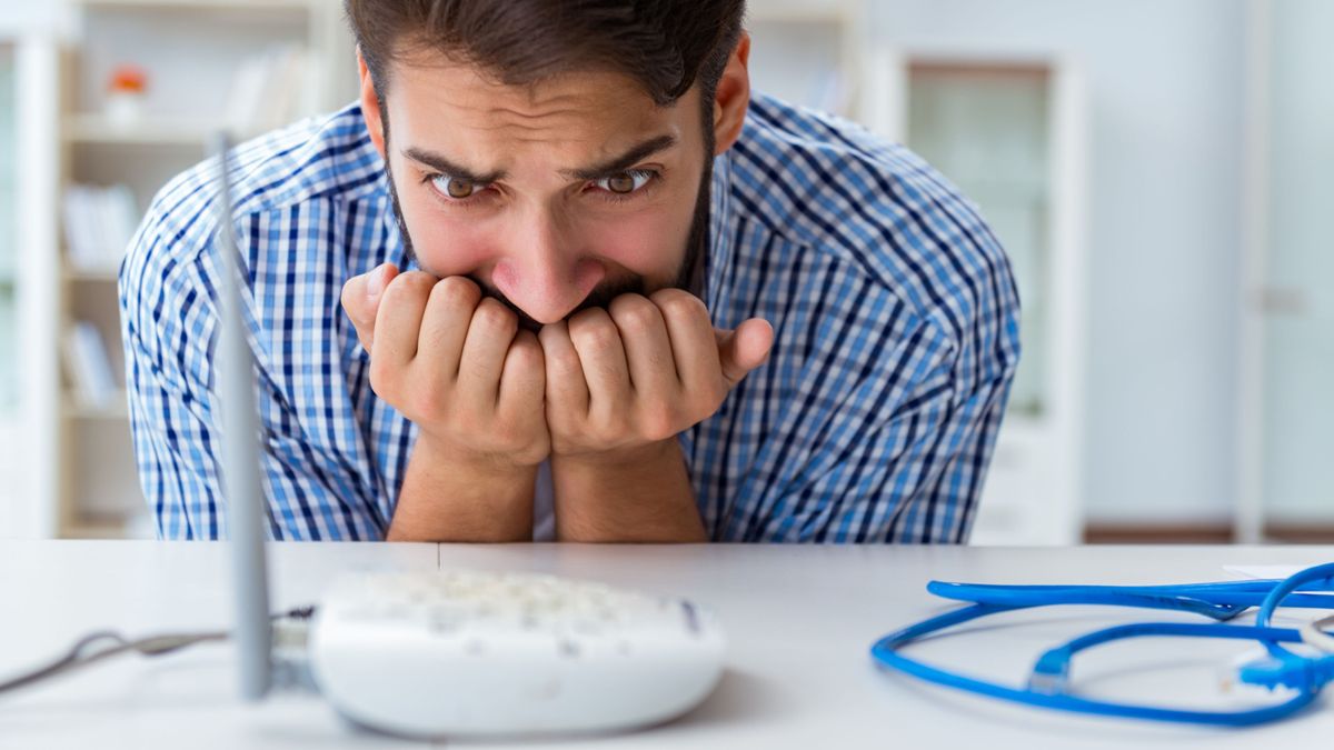 Man looking at his Wi-Fi router in fear