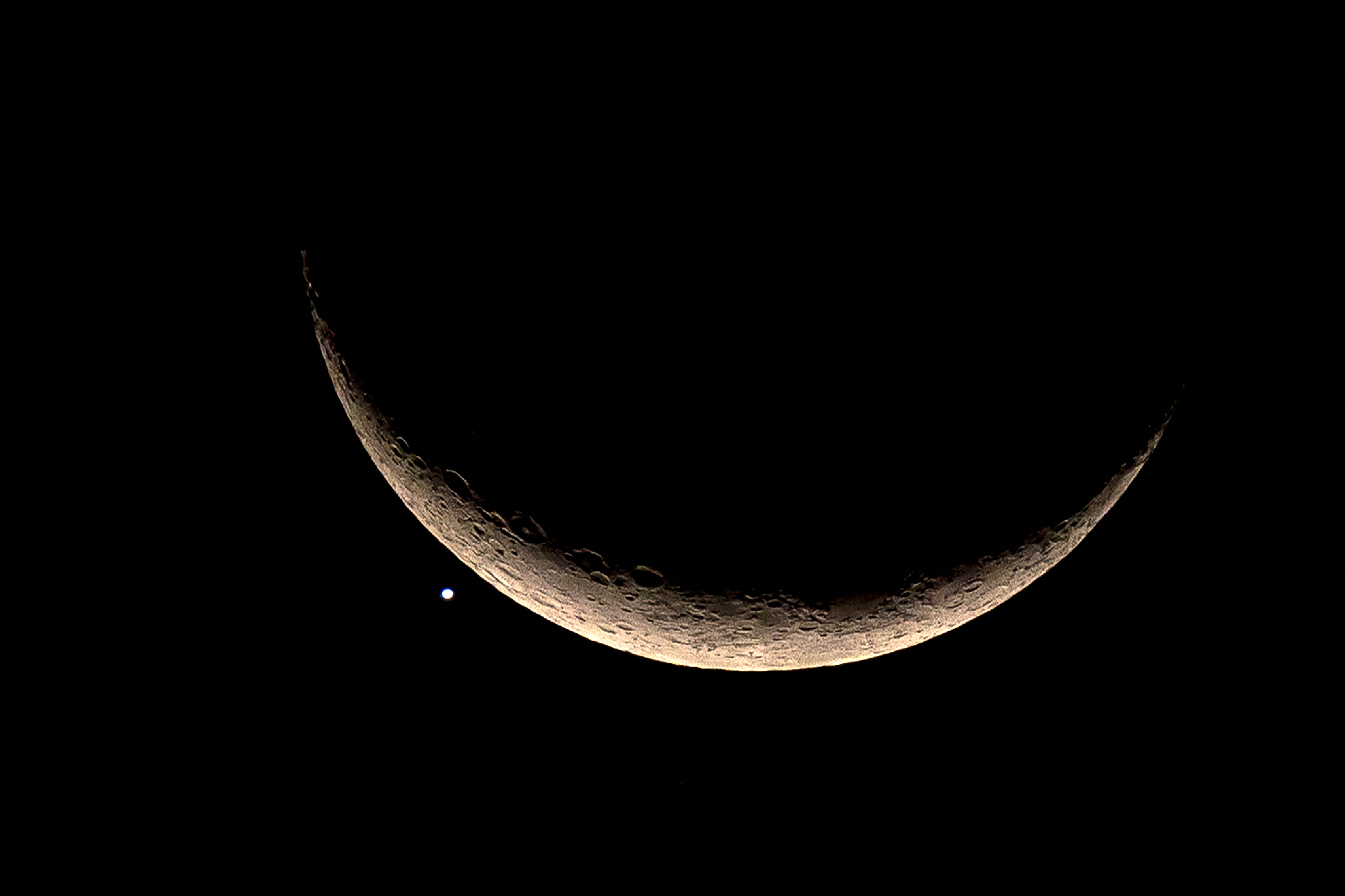 Un punto de luz brillante, Venus, junto a una luna creciente