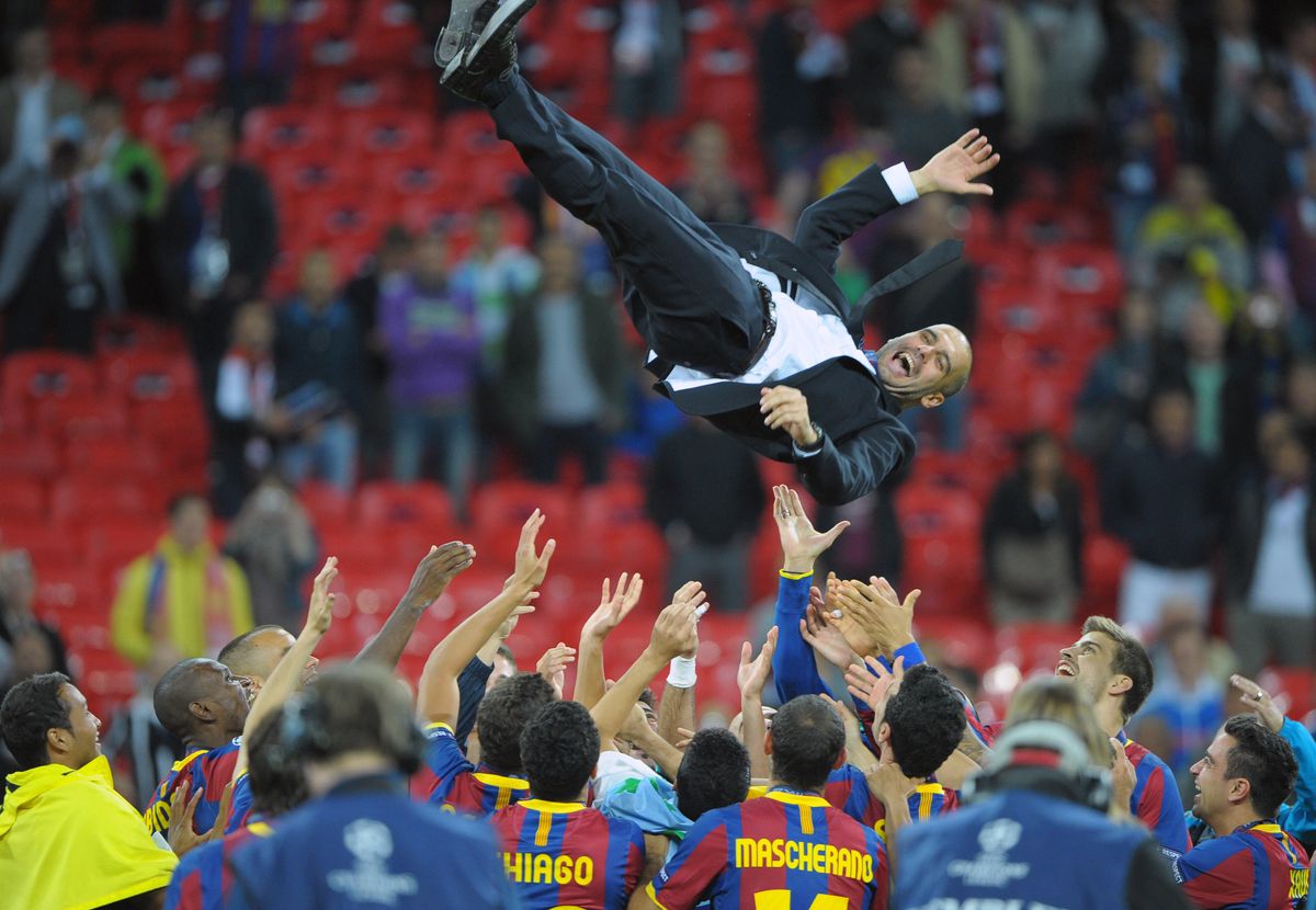 Barcelona players celebrate by tossing manager Pep Guardiola in the air after victory against Manchester United in the 2011 Champions League final at Wembley