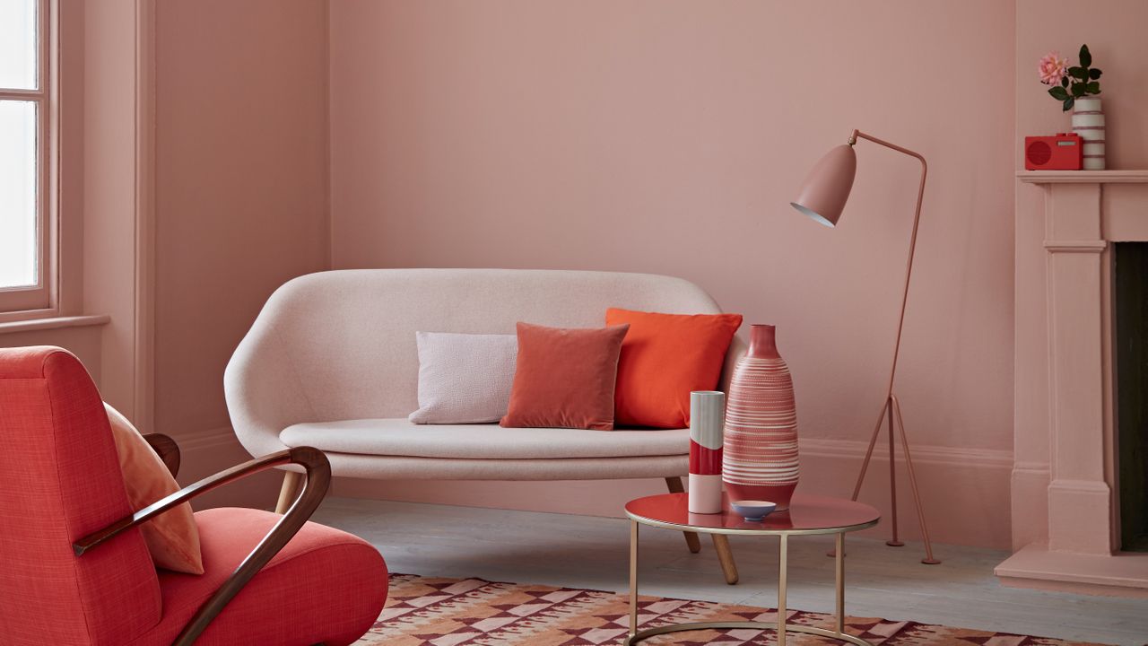 blush pink living room with sofa and little armchair by crown