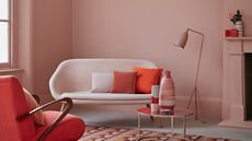 blush pink living room with sofa and little armchair by crown