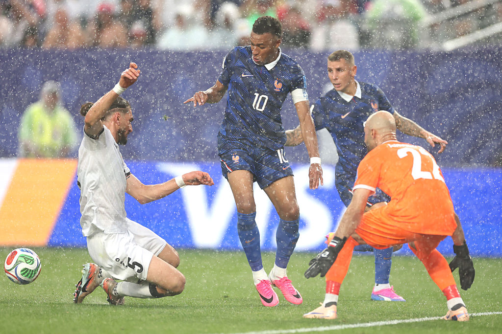 Kylian Mbappe tries to control the ball against Akam Hashim #5 and Ahmed Basil #22 of Iraq in the rain during the FIFA World Cup 2026 Group I match between France and Iraq
