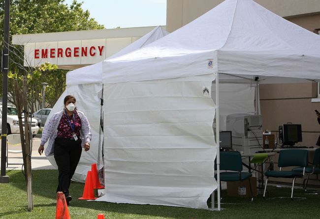 30 Nisan 2009 tarihinde Antakya, Kaliforniya'daki Sutter Delta Tıp Merkezi'ndeki acil servis odasının dışında kurulan bir triyaj çadırı tarafından yürüyen bir hemşire. Hastane, domuz gribi olabileceğinden endişe duyan potansiyel bir hasta seli için hazırlanıyordu. 