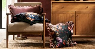 close up living room with wooden framed armchair and wooden sideboard with floral cushions from the new Marks and Spencer National Gallery collection