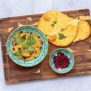 Typhoon World Foods End Grain Acacia Block with naan and pomegranate seeds in bowl