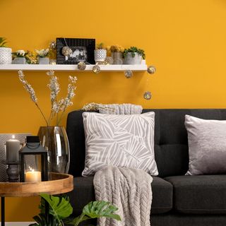 room with yellow wall and black sofa