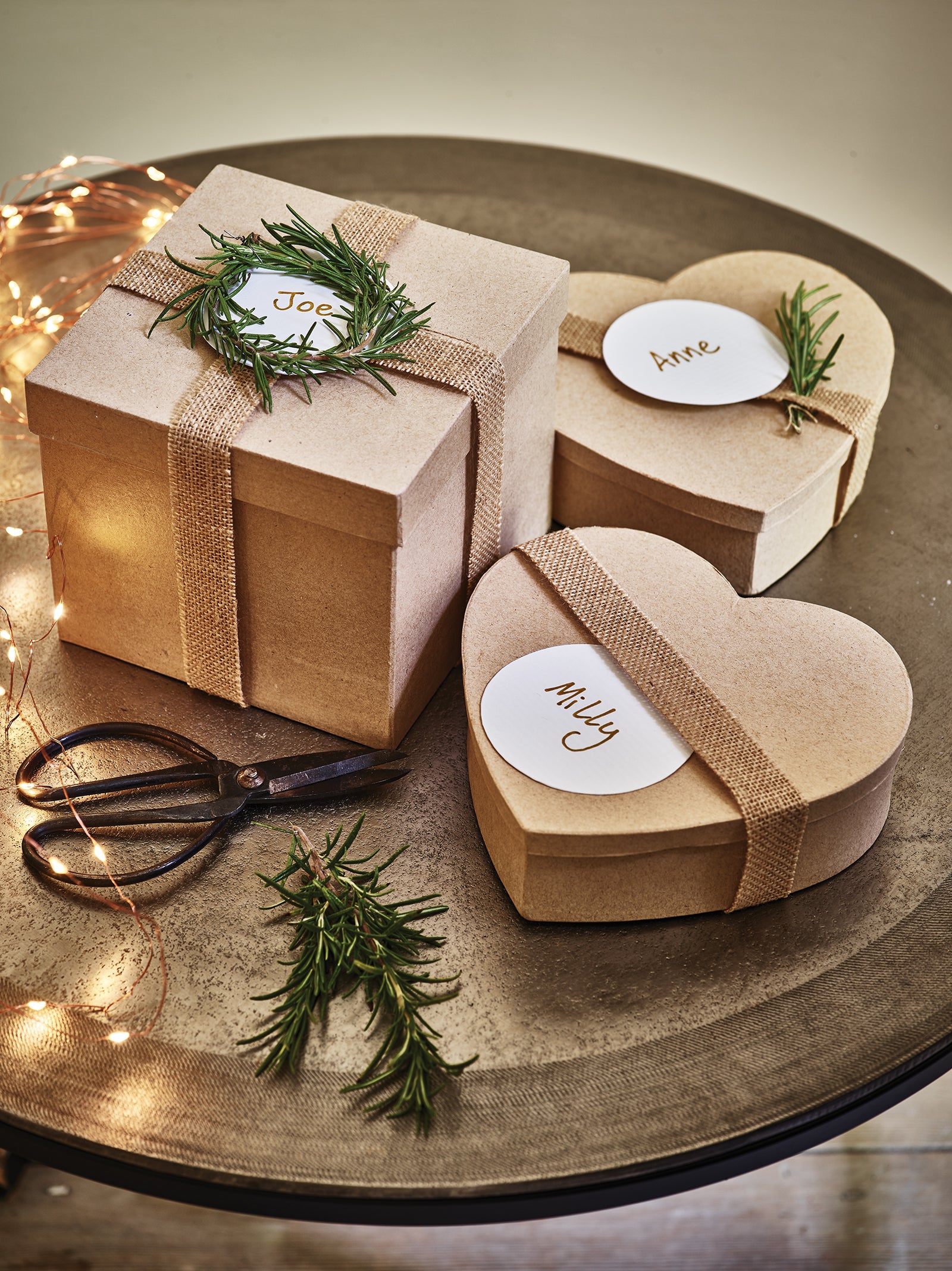 Brown gift boxes with hessian ribbons and rosemary used as foliage