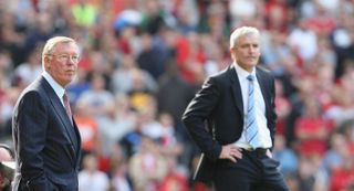 Manchester United manager Sir Alex Ferguson and Manchester boss Mark Hughes watch a derby between the two teams in September 2009.