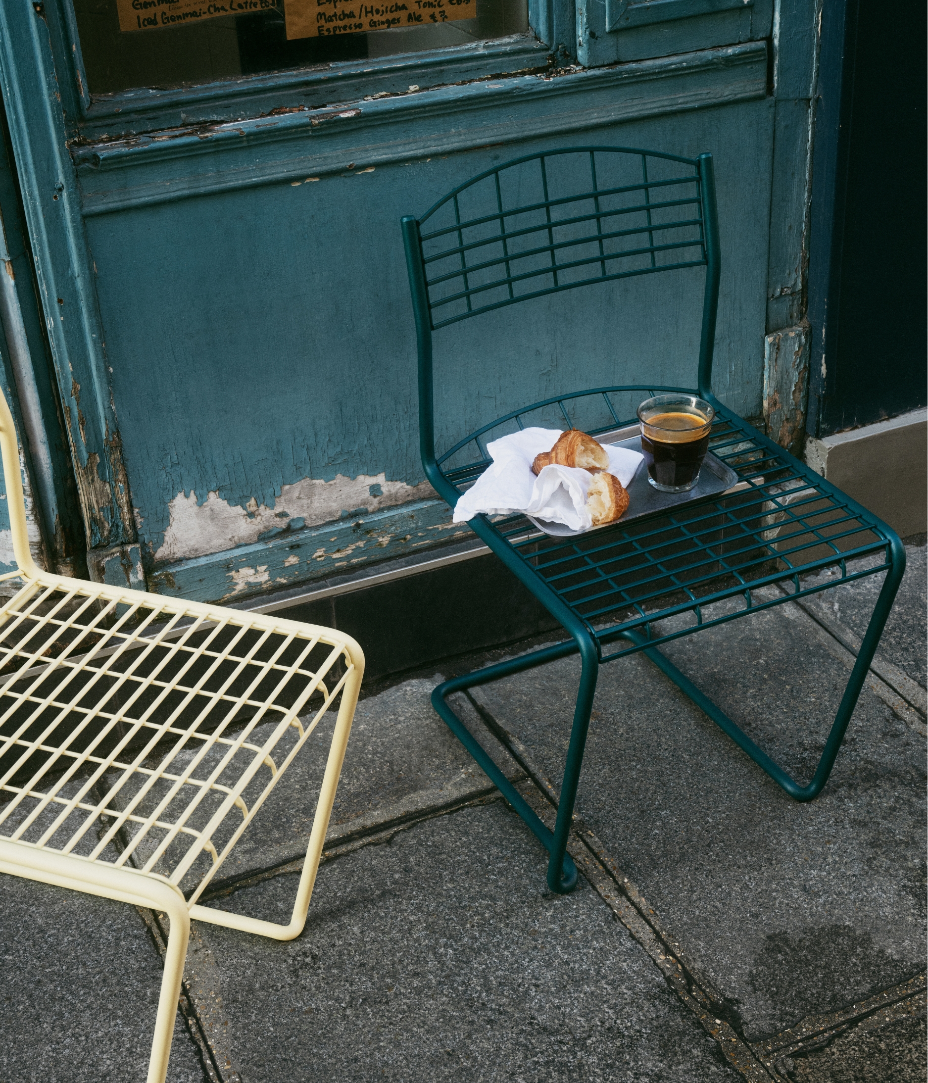 metal outdoor furniture on a street in paris with a croissant and coffee