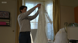 Eve Unwin holding up a wedding dress