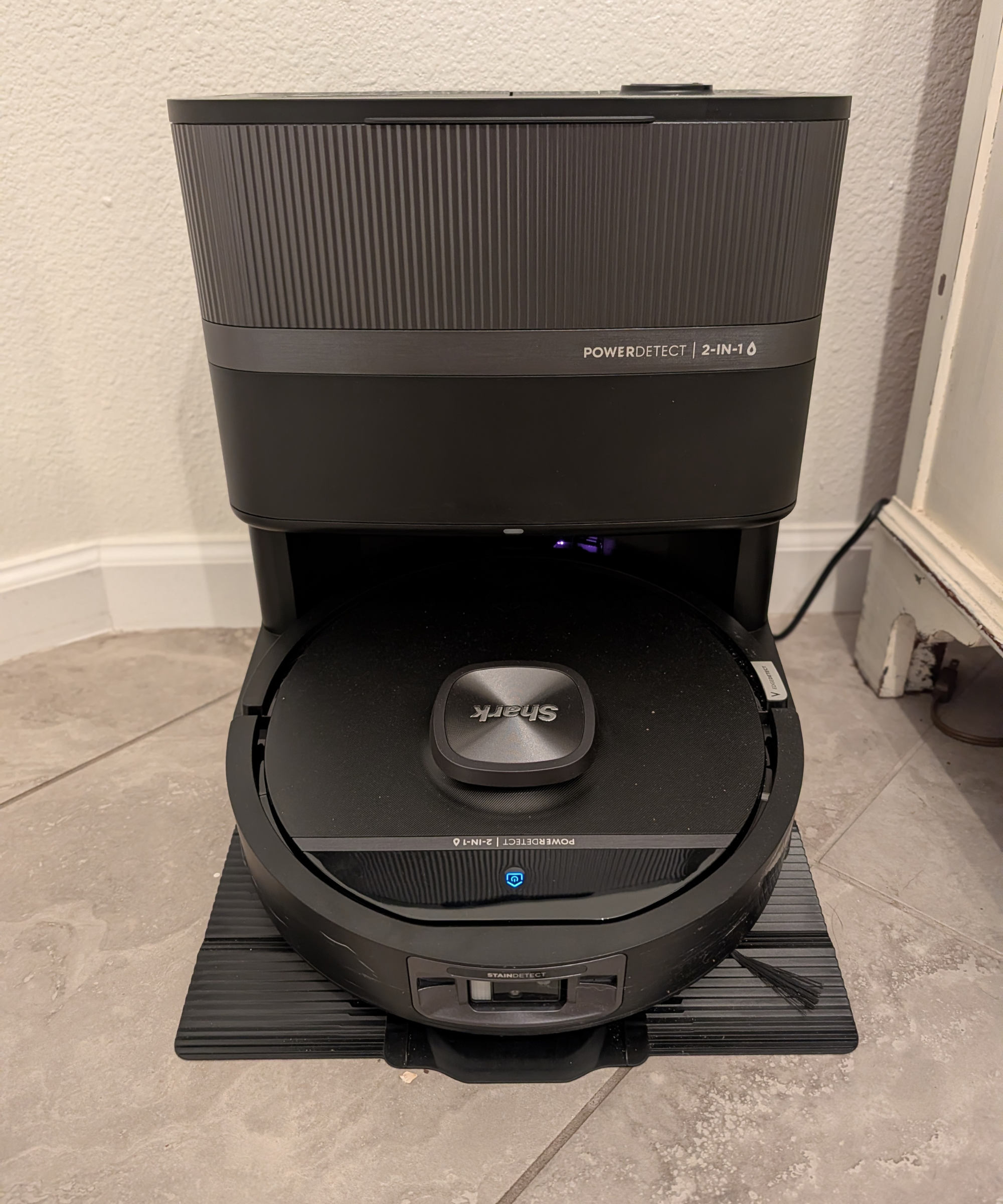 The PowerDetect UV Reveal in the docking station against a white wall.