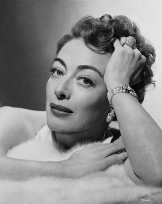 joan crawford looking glamorous in a fur in a promotional shot for the movie Sudden Fear