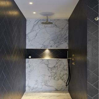 walk in shower with rainfall shower head, white and grey wall tiles and black wall tiles