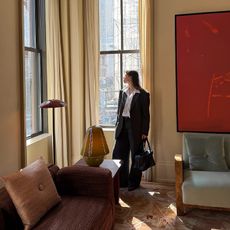 influencer poses looking outside of the window n a well decorated apartment