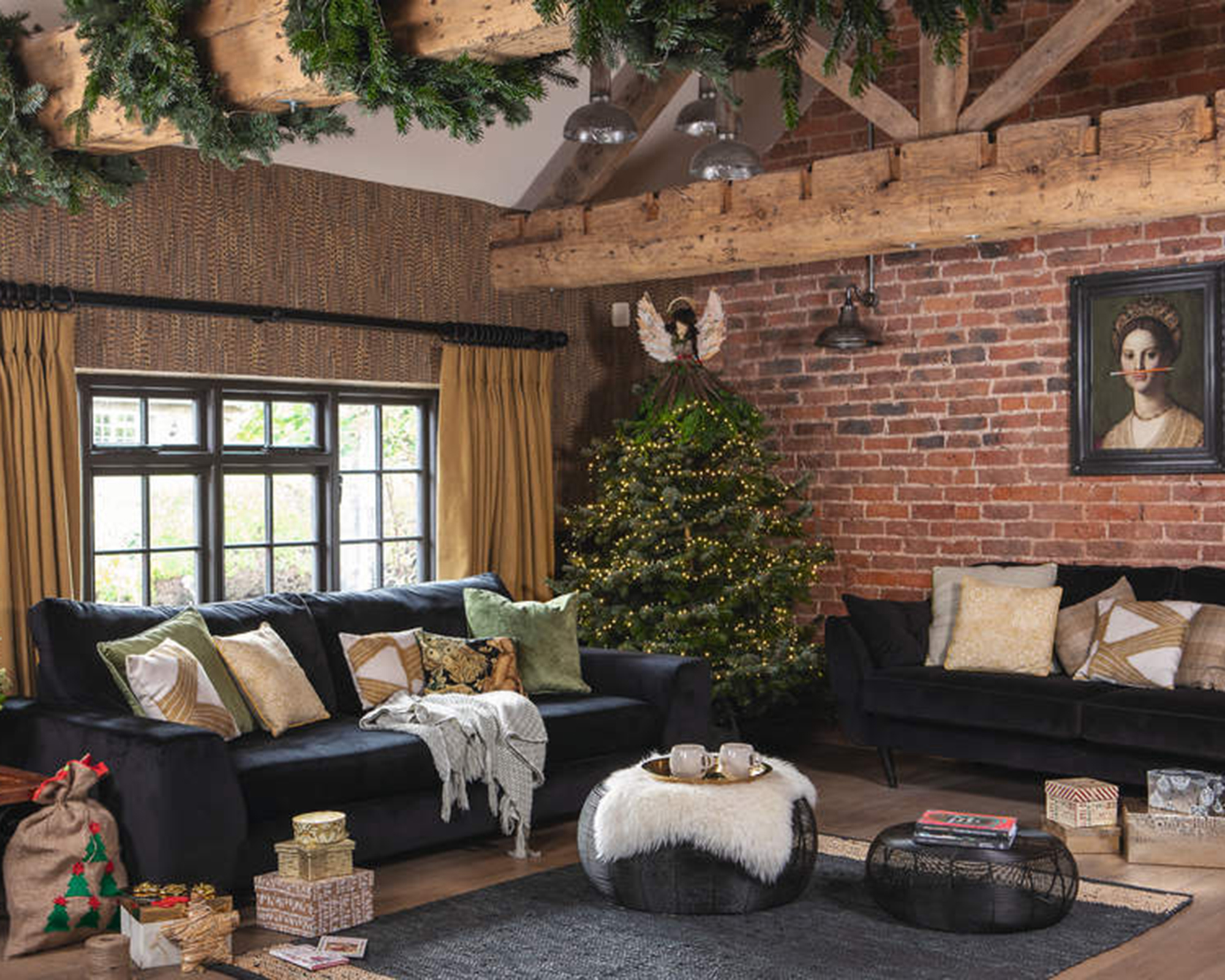 A living room decorated for Christmas with exposed brick wall decor and tree foliage