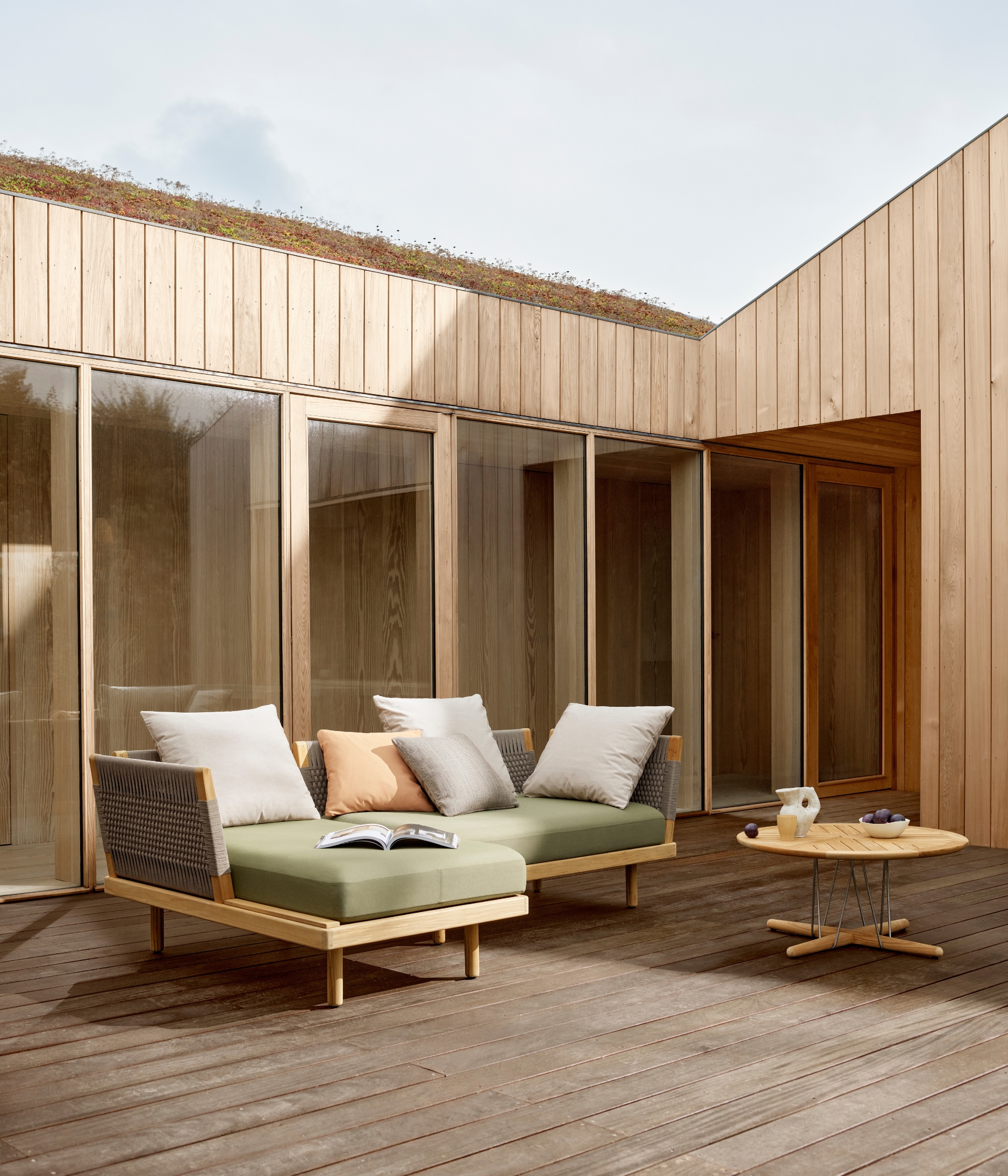 an outdoor sofa on a deck outside of a timber home