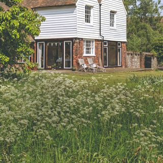 A country house with a back garden and a meadow