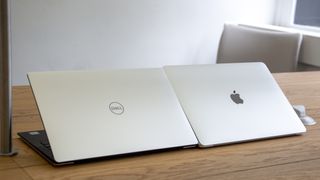 The Dell XPS 13 and Apple MacBook Pro 13in (2018) side-by-side with the lid half-open