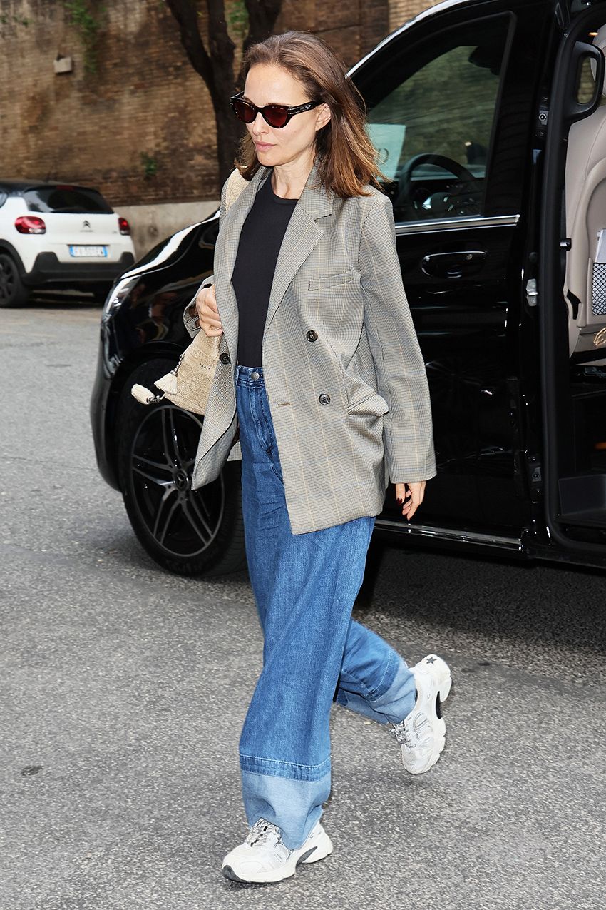 Natalie Portman wearing a blazer, black T-shirt, baggy jeans, and chunky sneakers