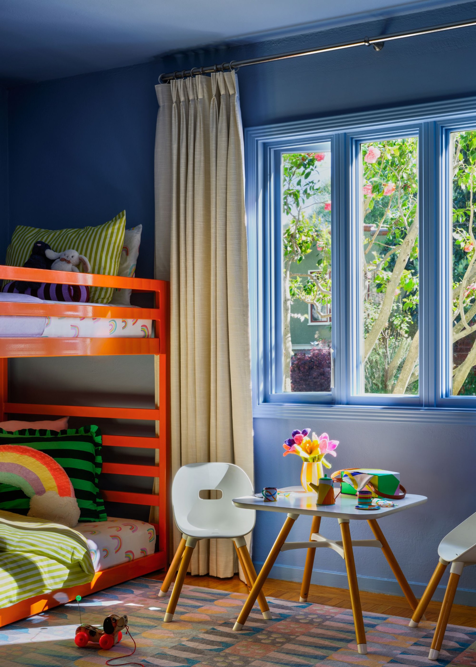 Kids bedroom with blue walls, a double-deck bed and a small study table