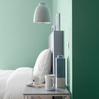 green bedroom with bed and hanging lamp light