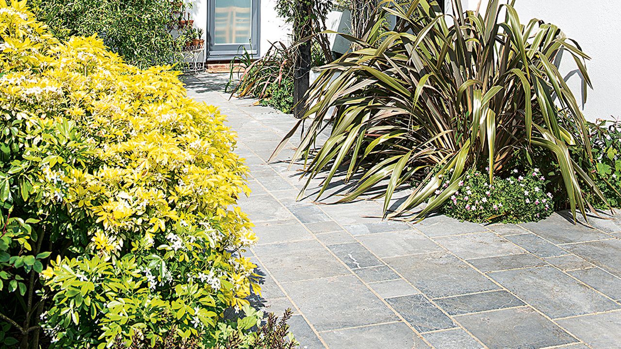 Block paving path leading to front door, surrounded by flower beds