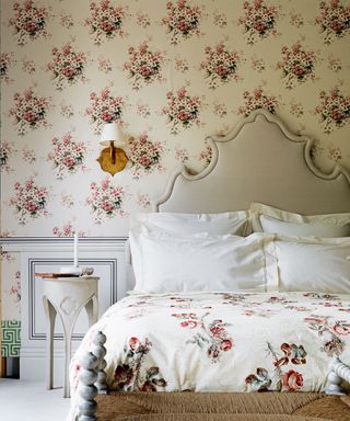 Floral wallpaper and bedlinen in a cream and pastel scheme, with statement headboard.