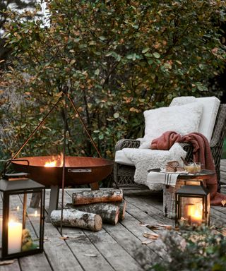 Decking with a firepit, lanterns and cozy outdoor armchair from Neptune