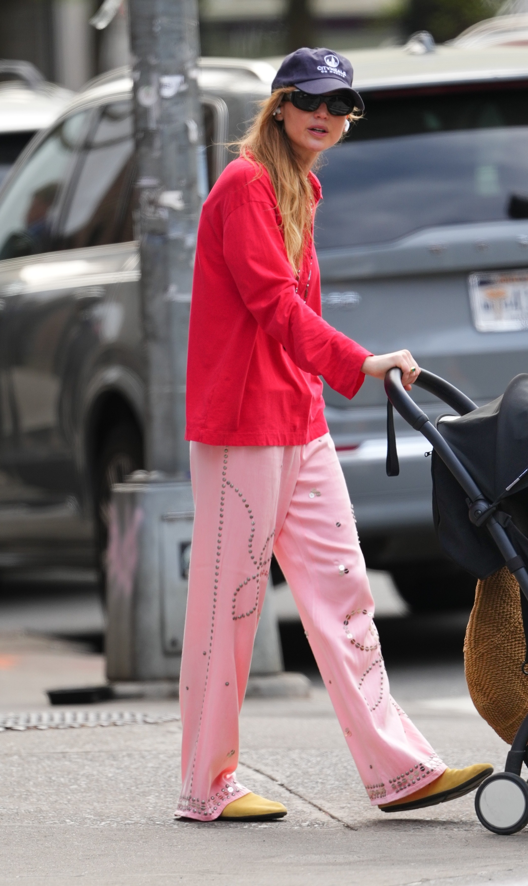 An image of Jennifer Lawrence wearing a red button-down shirt with pink pants and mules.