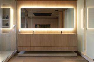 A bathroom with backlit mirror