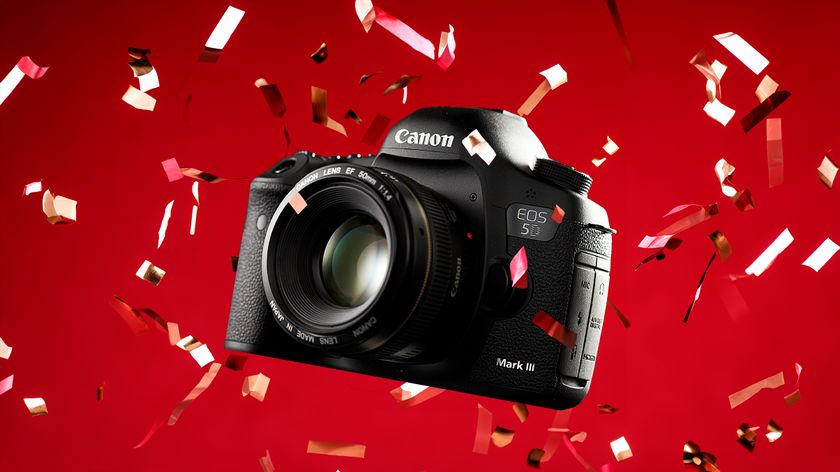 A Canon EOS 5D Mark III camera surrounded by colorful confetti against a vibrant red background, showcasing its sleek design
