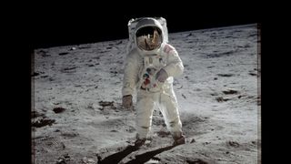 photo of man in spacesuit on grey surface