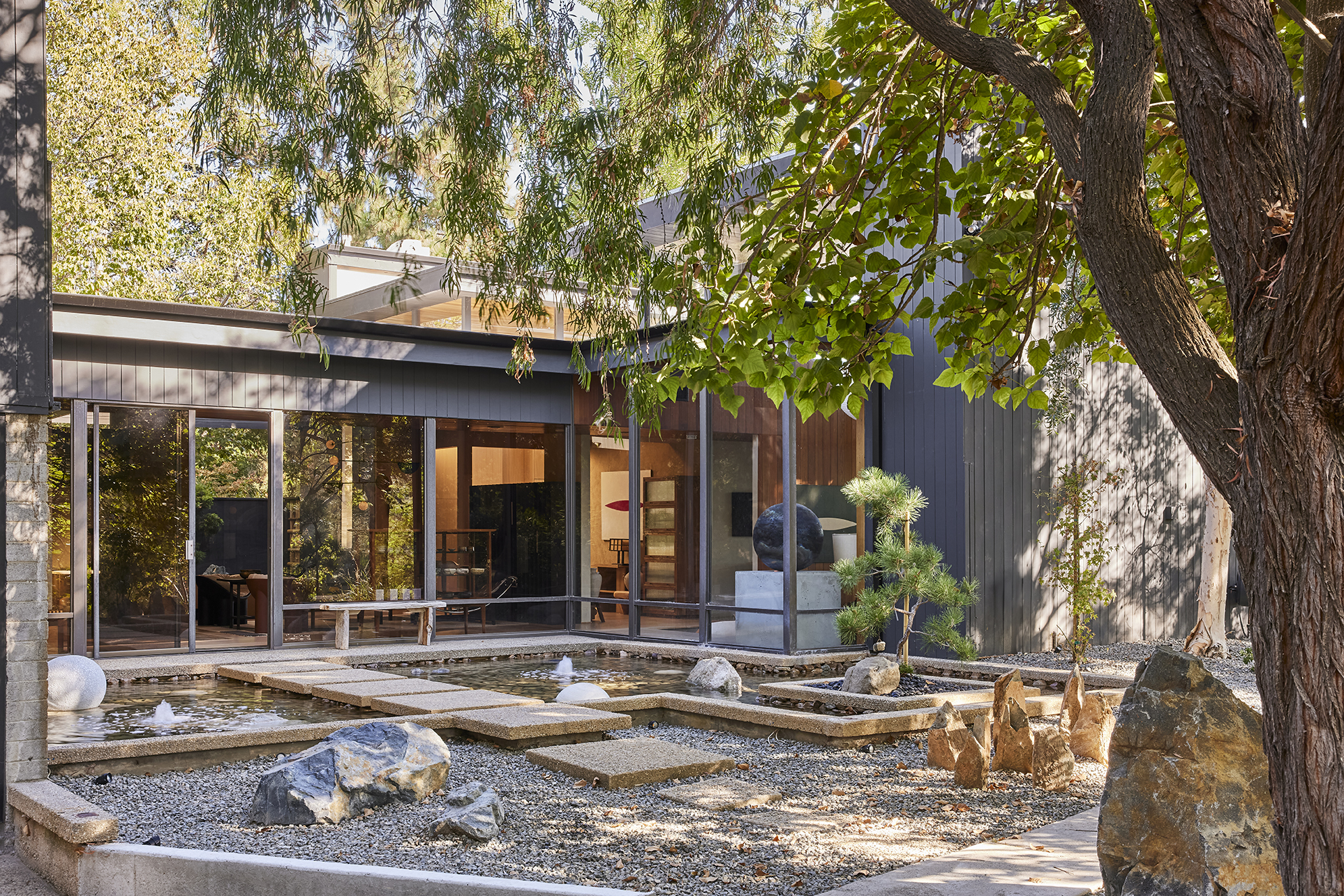 Japanese-inspired water garden and reflective courtyard, where stone, water, and native planting create a contemplative threshold between architecture and landscape.