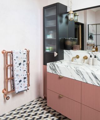 Black and pink bathroom with patterned tiled floor and tall ikea cabinet turned into bathroom storage