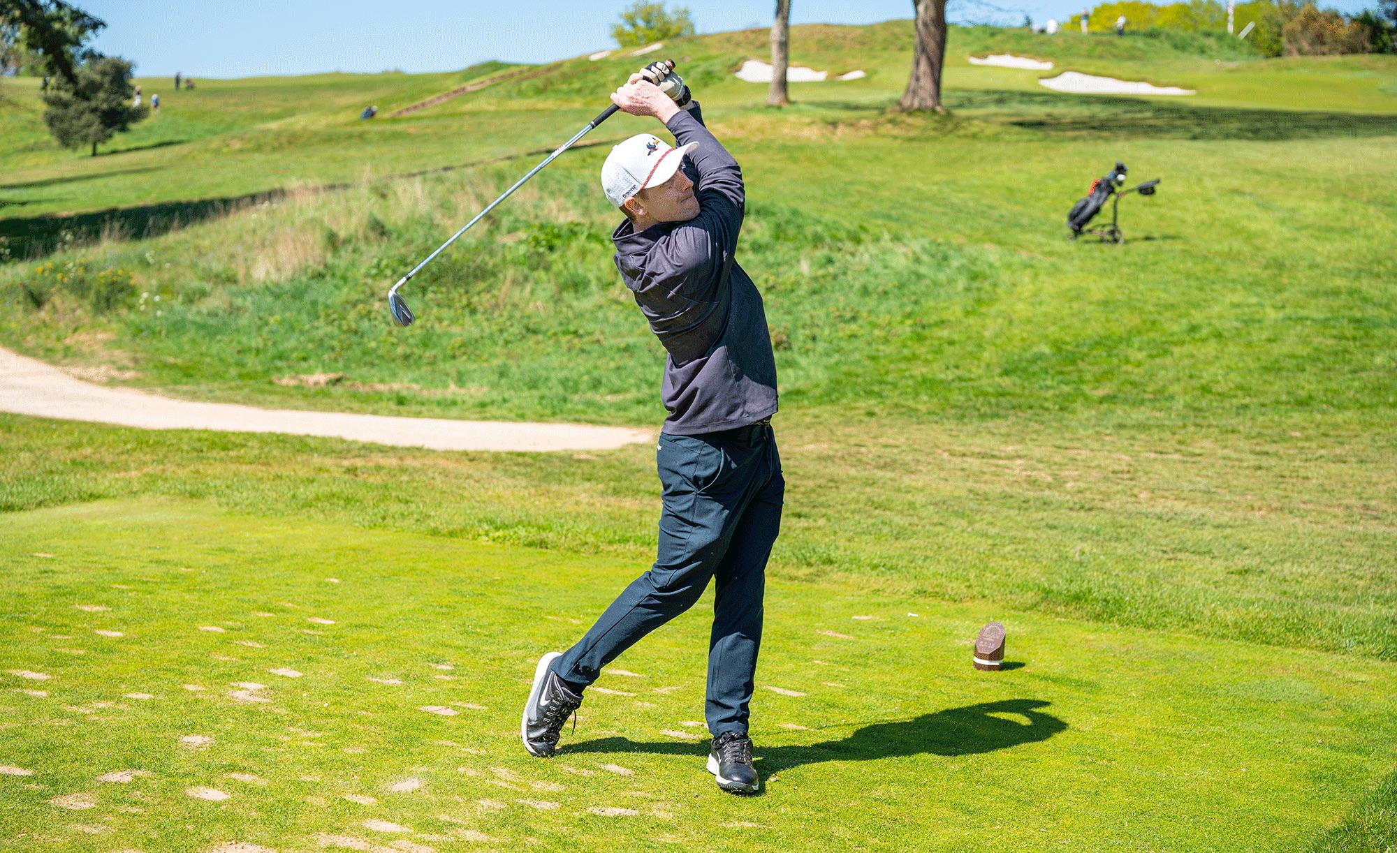 An amateur golfer hitting an iron shot into a par-3