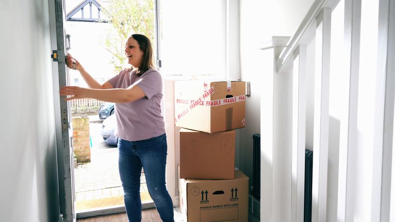 woman entering new house with boxes