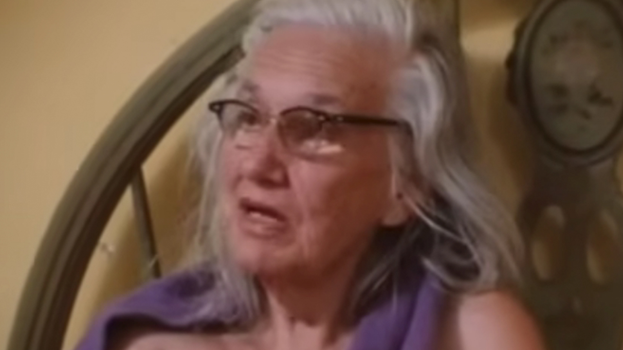 A closeup of "Big" Edie in her bed in Grey Gardens