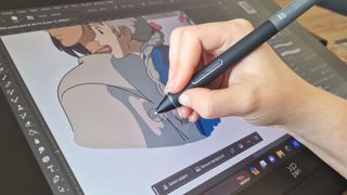 A close up of an artist painting on a drawing tablet screen with a stylus