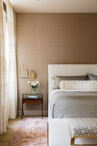 A bedroom with a brown/biege wallpaper