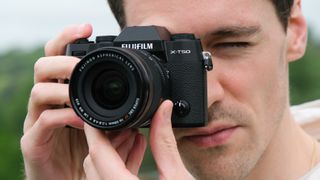 Fujifilm X-T50 camera held up a man's face
