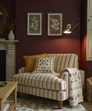 Dark red living room with armchair and metal wall light