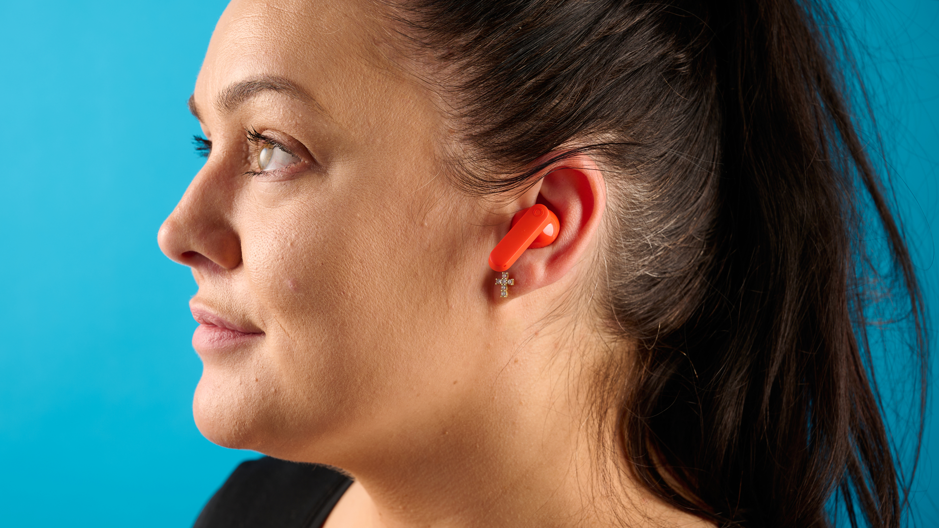cmf buds 2a in the orange colorway photographed in front of a blue background