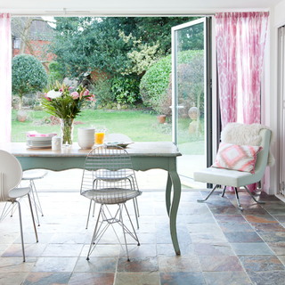 living room with dinning table and chair pink curtain and glass door