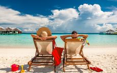 Couple in loungers on a tropical beach at Maldives